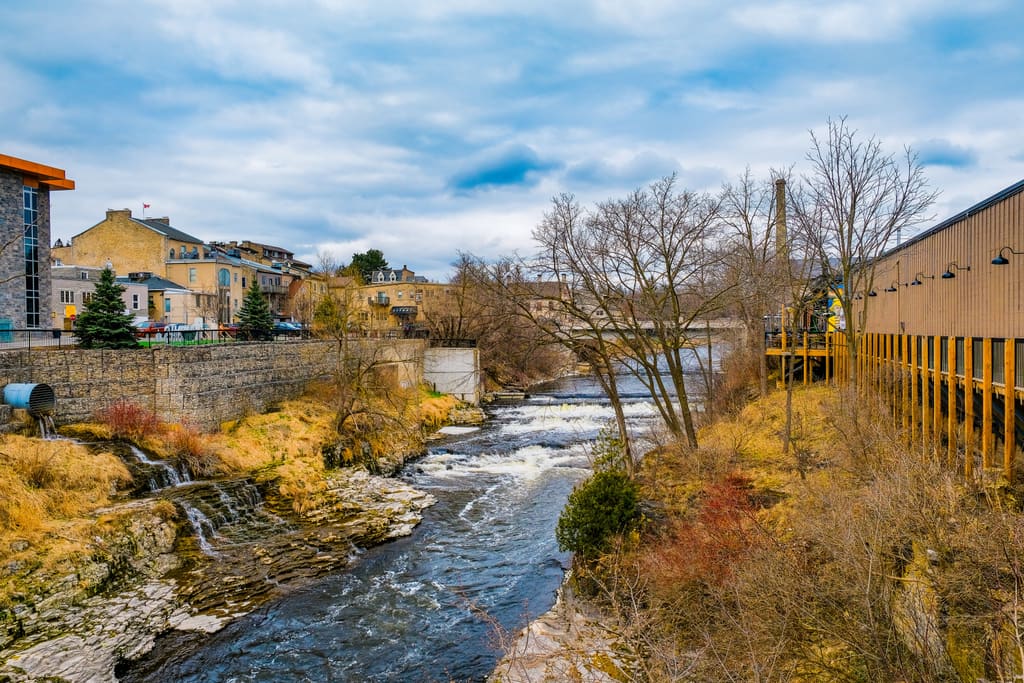 Historic stone buildings above rapids on the Grand River