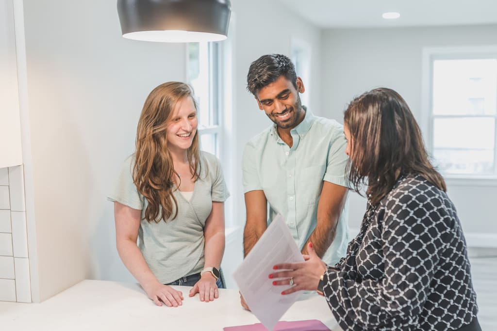 Property manager going through paperwork with two owners in an empty room