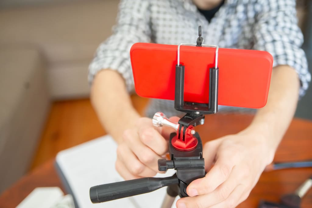 Phone being set up on a tripod to film short-form video in a home