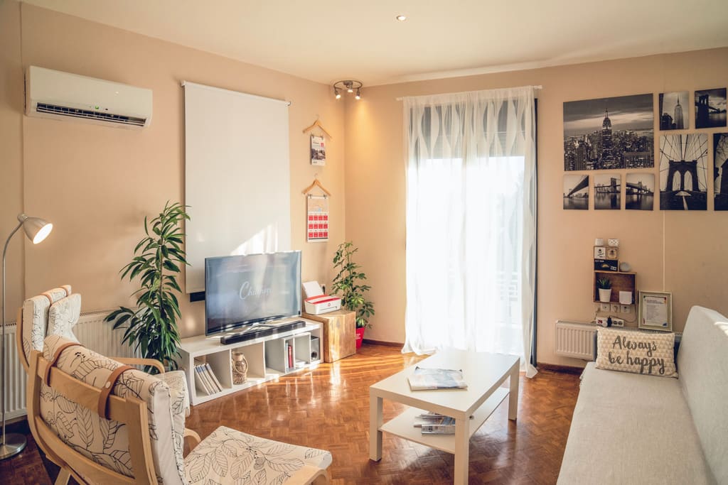 Warmly furnished apartment living room with a balcony door and framed prints